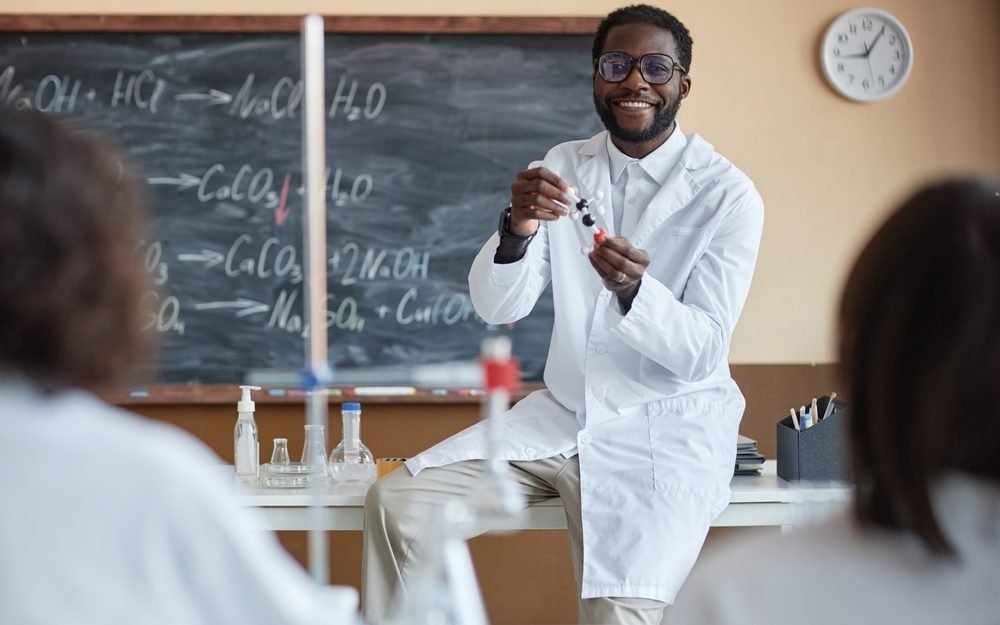 Un professeur de chimie conduit une expérience devant sa classe